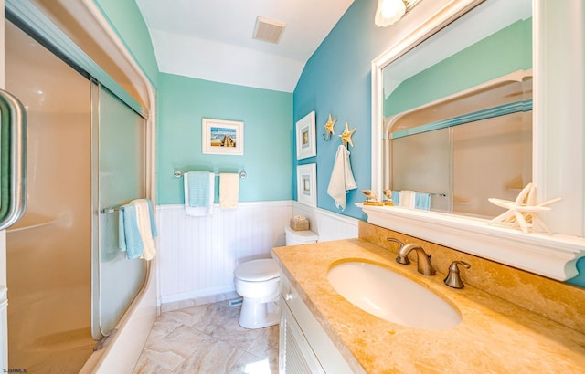 bathroom with visible vents, a wainscoted wall, toilet, shower / bath combination with glass door, and vanity