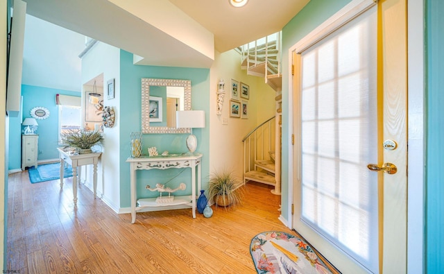 entryway with stairway, baseboards, and wood finished floors