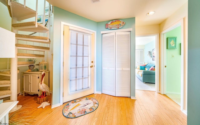 doorway to outside featuring stairs, wood finished floors, and baseboards