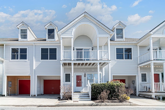 multi unit property featuring a garage and driveway