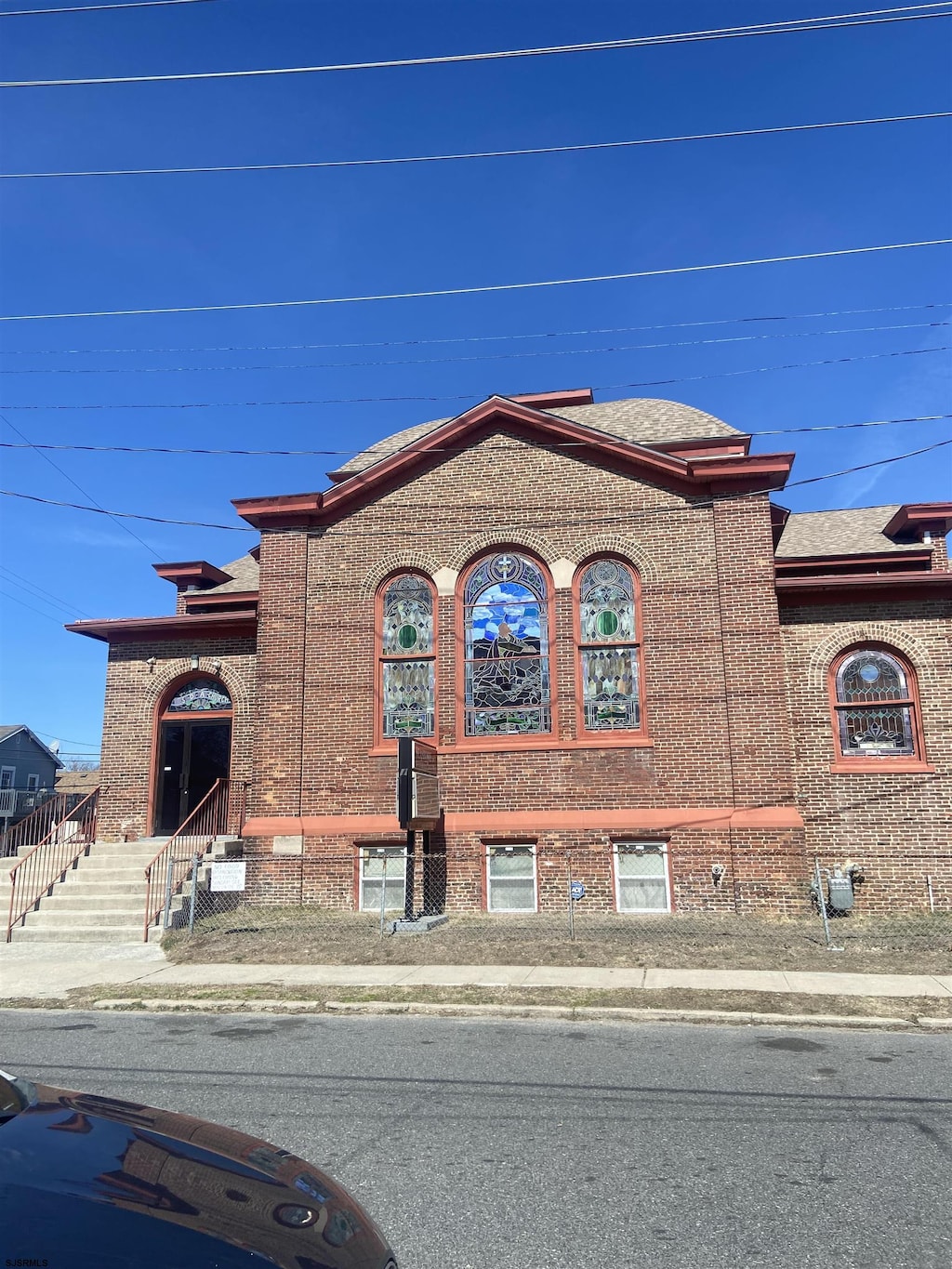 view of front facade featuring brick siding and a shingled roof