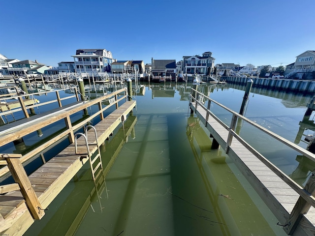 view of dock with a residential view and a water view