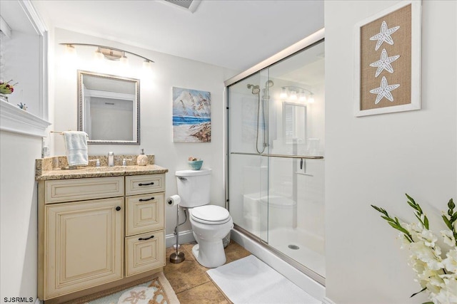 bathroom with tile patterned flooring, a stall shower, toilet, and vanity