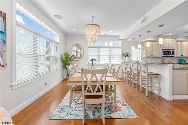 dining area with visible vents, baseboards, and light wood-style floors