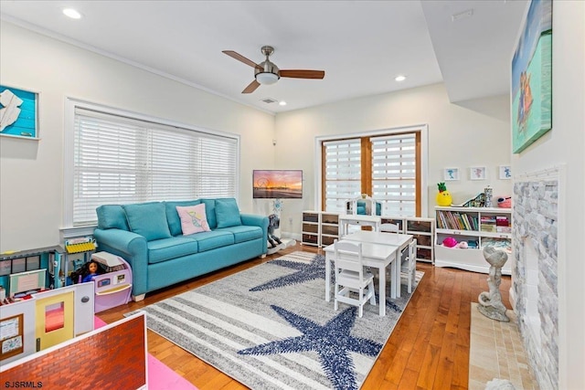 living area featuring visible vents, ceiling fan, ornamental molding, recessed lighting, and wood-type flooring