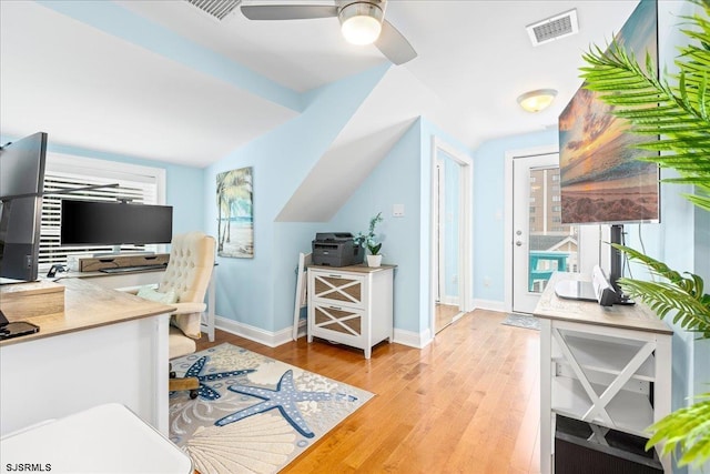 office space featuring visible vents, a healthy amount of sunlight, lofted ceiling, and wood finished floors