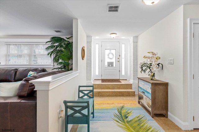 foyer with tile patterned floors, visible vents, and baseboards