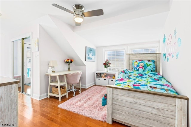 bedroom with a ceiling fan, vaulted ceiling, wood finished floors, and baseboards