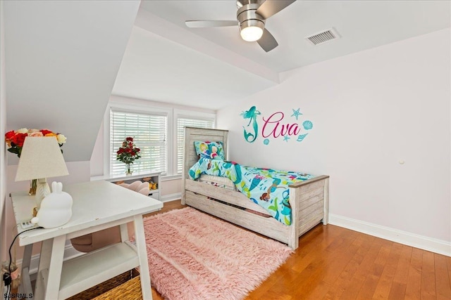 bedroom featuring visible vents, a ceiling fan, baseboards, and wood finished floors