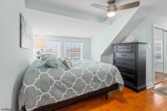 bedroom featuring wood finished floors, baseboards, and ceiling fan