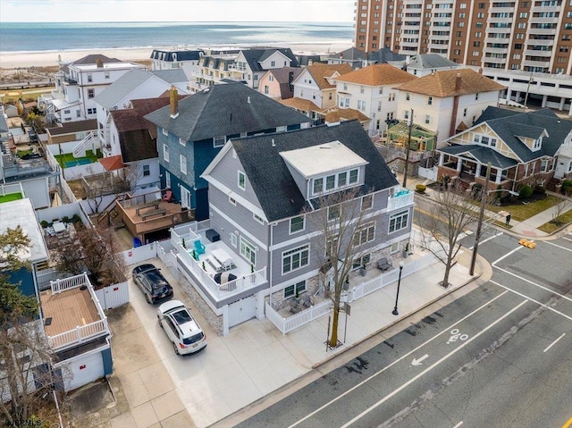 drone / aerial view featuring a view of the beach, a water view, and a residential view