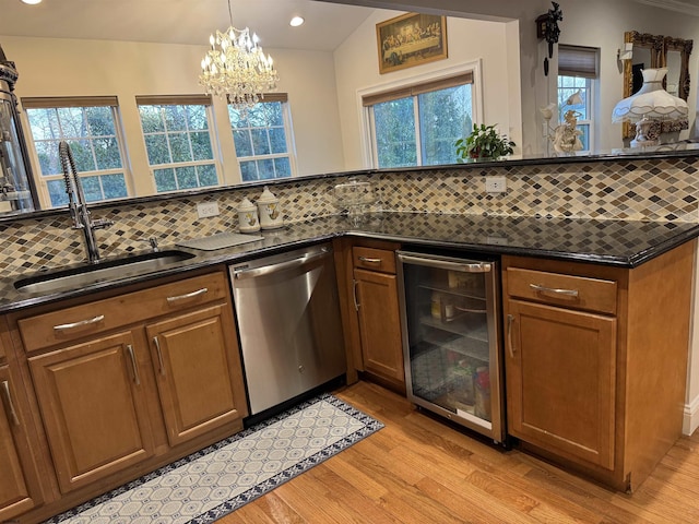 kitchen featuring light wood-style flooring, a sink, backsplash, stainless steel dishwasher, and wine cooler