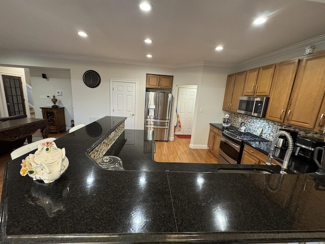 kitchen with backsplash, appliances with stainless steel finishes, brown cabinetry, and crown molding