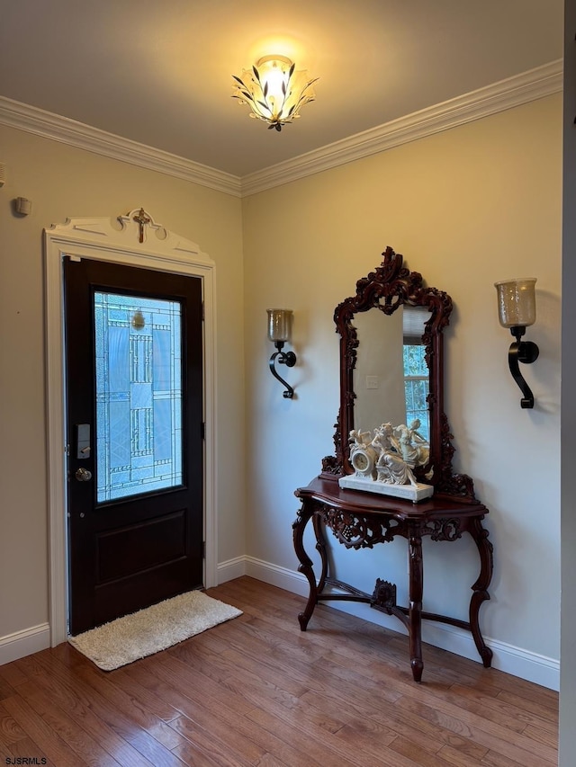 entryway with baseboards, wood-type flooring, and ornamental molding