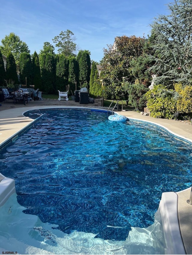 outdoor pool with a patio area