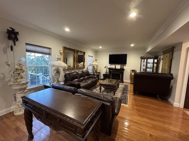 living area featuring baseboards, a fireplace, recessed lighting, hardwood / wood-style flooring, and crown molding