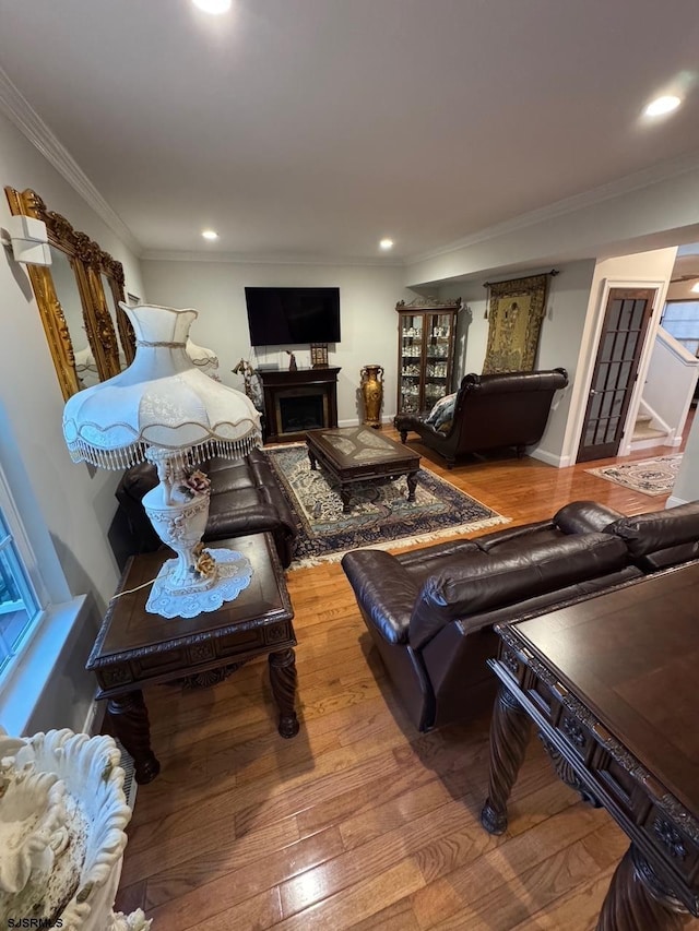 living room with recessed lighting, a fireplace, wood finished floors, and crown molding