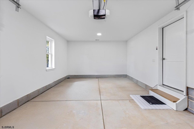 garage with a garage door opener and baseboards