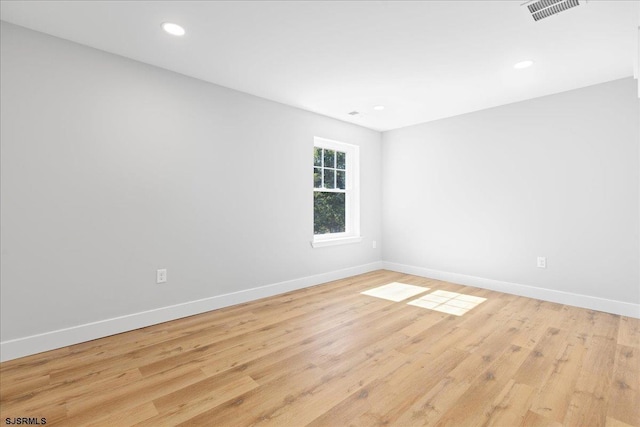 spare room featuring visible vents, recessed lighting, baseboards, and wood finished floors