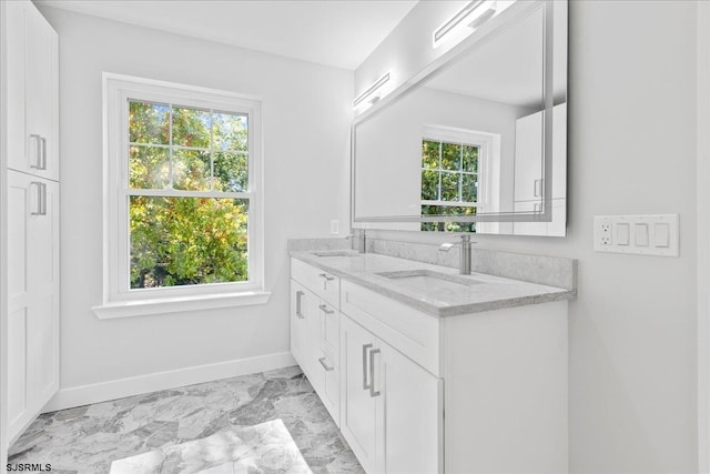 full bathroom featuring a sink, marble finish floor, and a healthy amount of sunlight