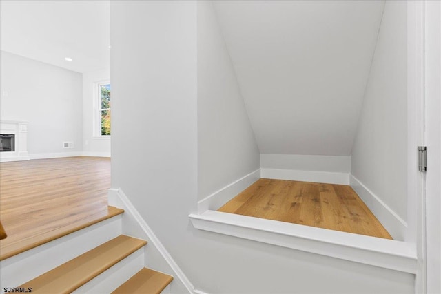 staircase with recessed lighting, a fireplace, and baseboards