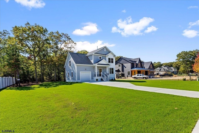 view of front of property featuring a garage, driveway, a front lawn, and fence