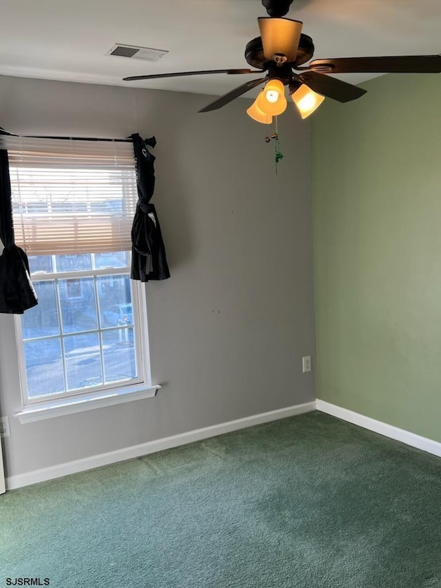 empty room with visible vents, baseboards, ceiling fan, and carpet flooring