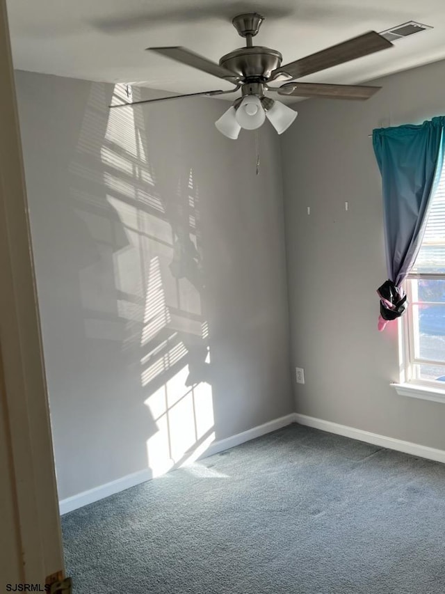 carpeted empty room with baseboards and ceiling fan