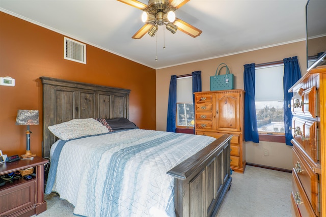 bedroom with visible vents, light colored carpet, ornamental molding, and a ceiling fan