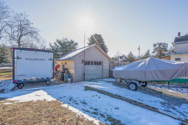 snow covered garage featuring a detached garage