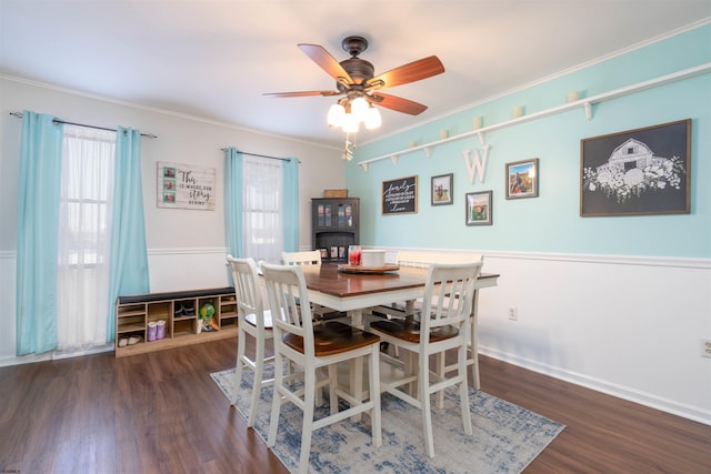 dining area with wood finished floors, ornamental molding, and a ceiling fan