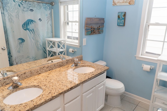 bathroom featuring tile patterned flooring, toilet, baseboards, and a sink