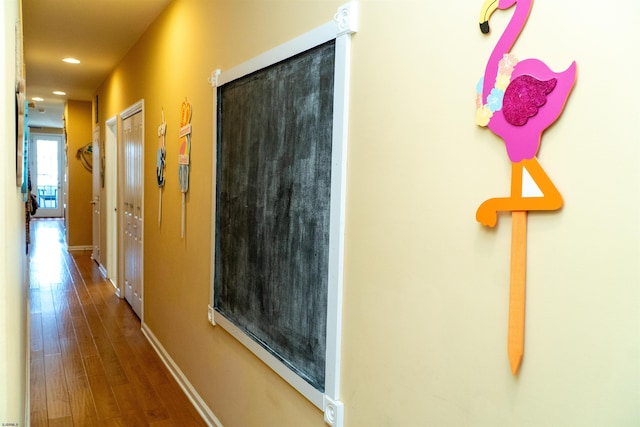 corridor featuring recessed lighting, baseboards, and wood finished floors