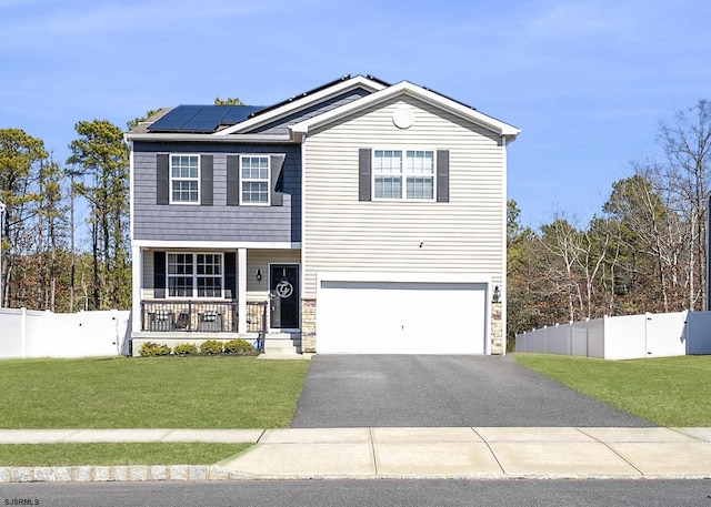 view of front of property featuring a porch, fence, a front yard, and roof mounted solar panels