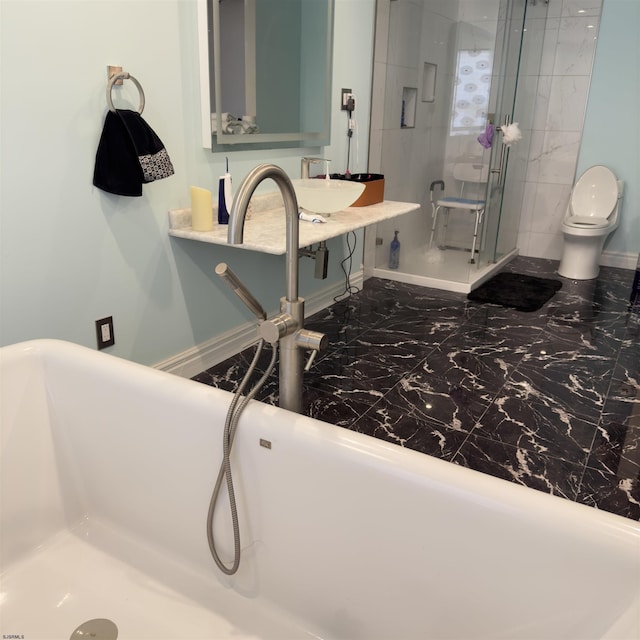 full bath featuring a freestanding tub, toilet, baseboards, and a stall shower