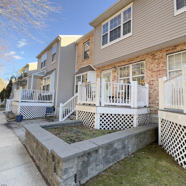 exterior space with brick siding and covered porch