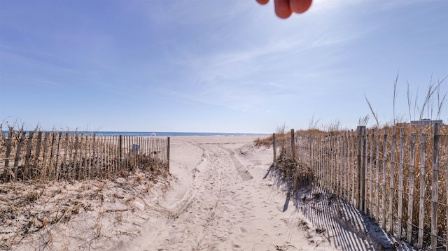 view of water feature with a view of the beach and fence