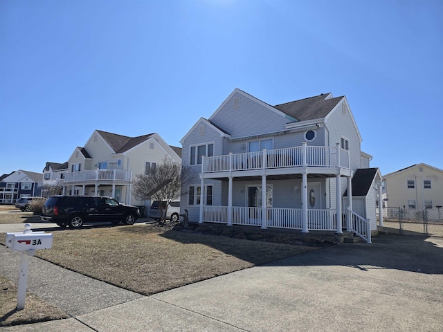 view of front facade featuring a porch, a balcony, and a residential view