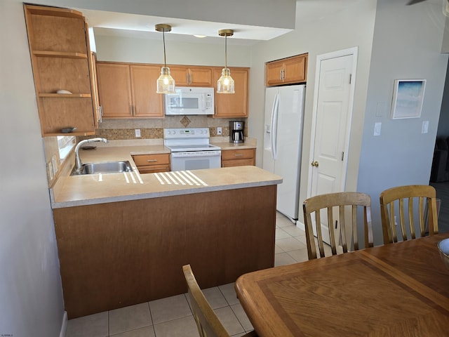 kitchen featuring backsplash, light countertops, a peninsula, white appliances, and a sink