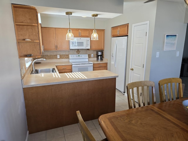 kitchen with white appliances, a peninsula, a sink, light countertops, and tasteful backsplash