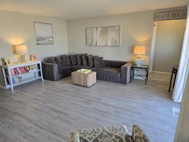 living room featuring wood finished floors, visible vents, and baseboards