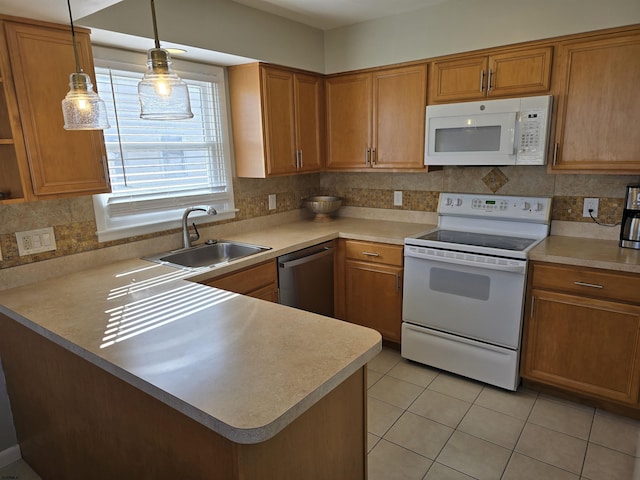 kitchen with white appliances, light countertops, tasteful backsplash, and a sink