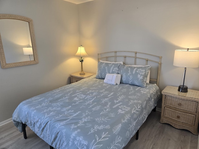 bedroom with baseboards and wood finished floors