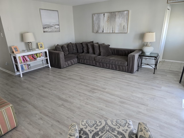 living area with baseboards and wood finished floors