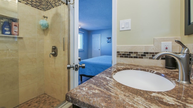 bathroom featuring vanity, a shower stall, and a textured ceiling