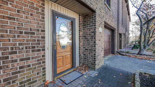 view of exterior entry featuring brick siding and board and batten siding