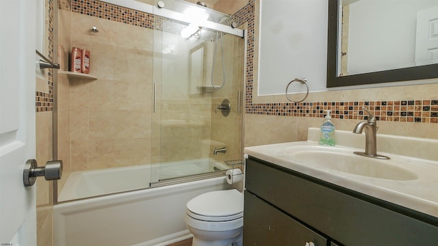 full bath featuring backsplash, tile walls, toilet, shower / bath combination with glass door, and vanity