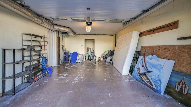 garage featuring concrete block wall and a garage door opener