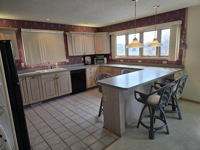 kitchen with light tile patterned flooring, a sink, black appliances, a textured ceiling, and a kitchen bar