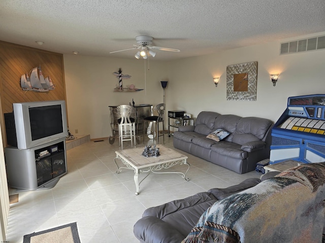 living area with visible vents, a textured ceiling, and tile patterned flooring